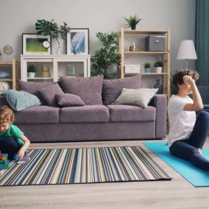 a woman sitting on a yoga mat with a child