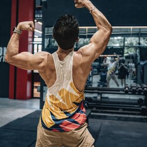 Man flexes muscles in a gym.